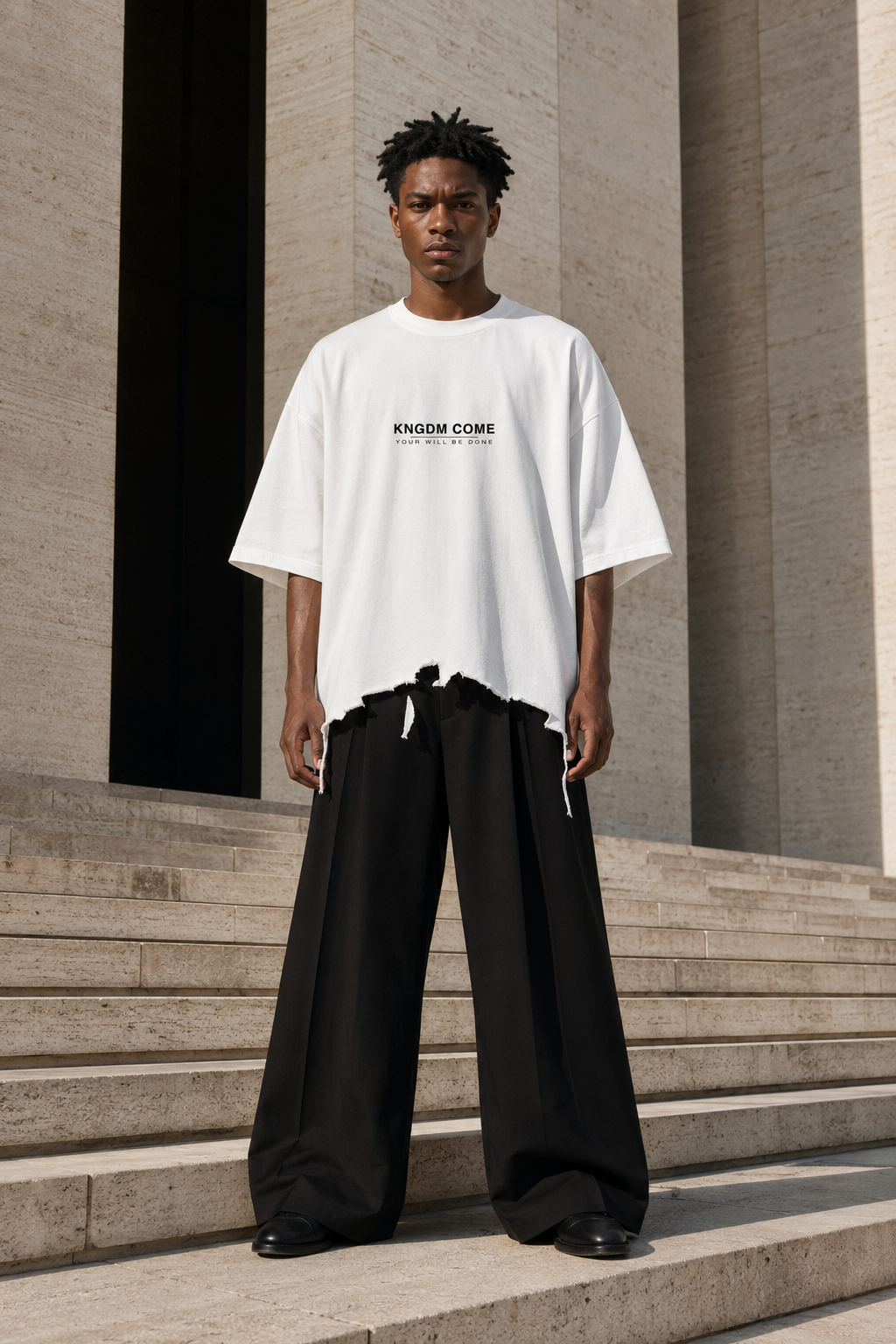 Model wearing the front of an oversized white Made Clothing Co. KNGDM COME T-shirt.